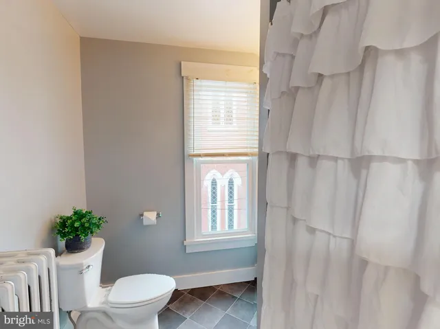 a white toilet sitting next to a window