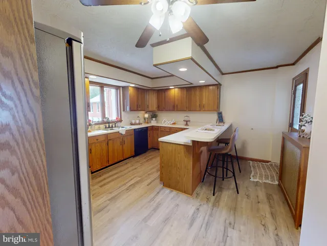 a kitchen with a table chairs a sink dishwasher stove and cabinets with wooden floor