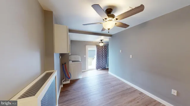 a view of a hallway with wooden floor and a ceiling fan
