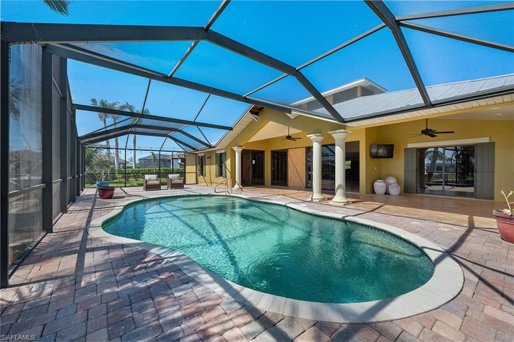 390 Randy Lane Fort Myers Beach, FL 33931 - Photo 17 of 19 a view of a patio with table and chairs under an umbrella