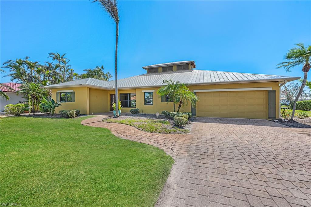 390 Randy Lane Fort Myers Beach, FL 33931 - Photo 2 of 19 a front view of a house with a garden and yard