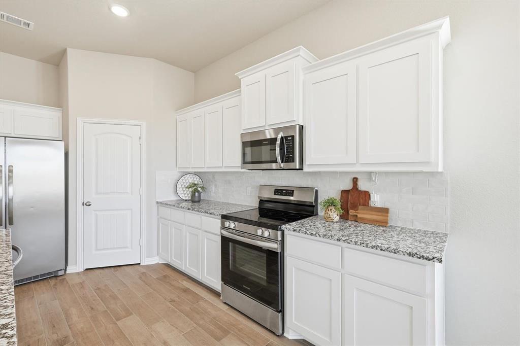 139 Steppes Court Decatur, TX 76234 - Photo 23 of 40 a kitchen with granite countertop white cabinets stainless steel appliances and a sink