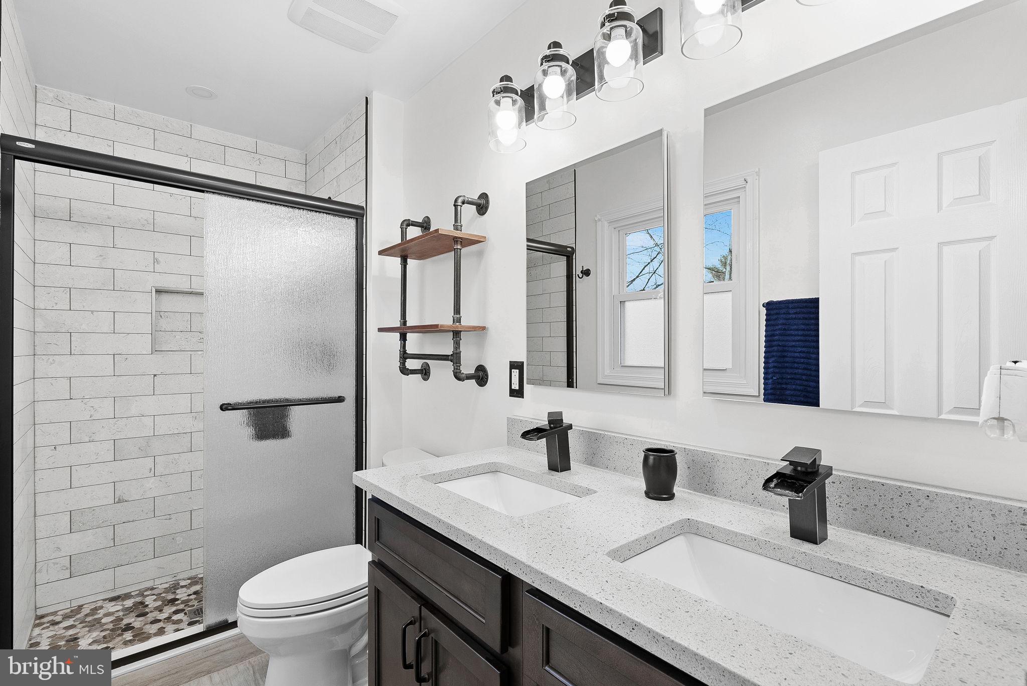 6130 Windward Drive Burke, VA 22015 - Photo 23 of 50 a bathroom with a granite countertop sink toilet and shower