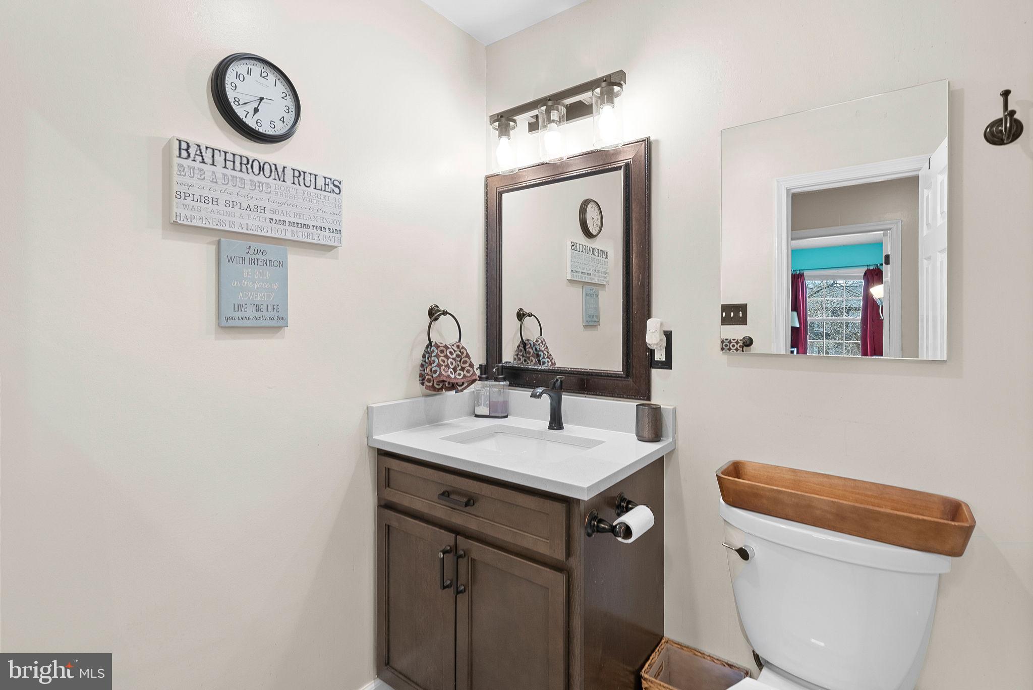 6130 Windward Drive Burke, VA 22015 - Photo 31 of 50 a bathroom with a toilet a sink and a mirror