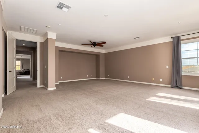 a view of an empty room with a window and a ceiling fan
