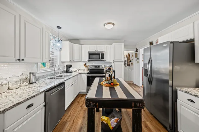 a view of a kitchen with sink microwave and refrigerator