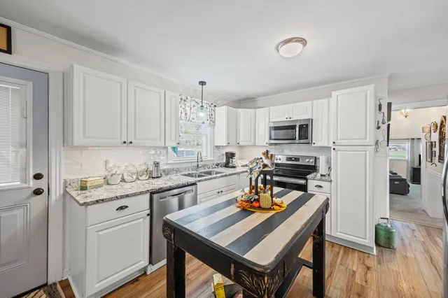 a kitchen with stainless steel appliances cabinets a sink and a center island