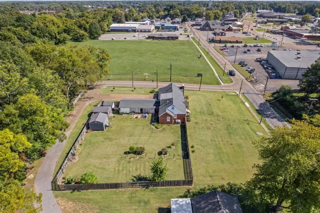 an aerial view of a pool with a yard