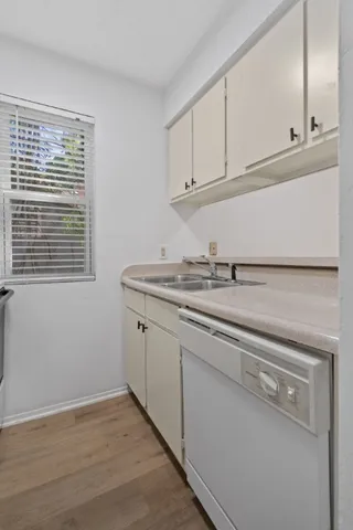 a kitchen with granite countertop white cabinets and a sink