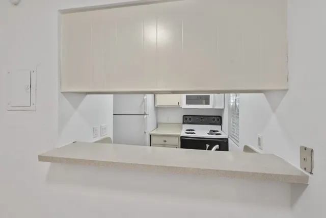 a kitchen with kitchen island a sink and white cabinets