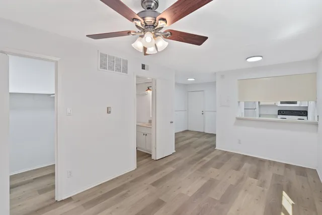 a view of a kitchen with wooden floor and a ceiling fan