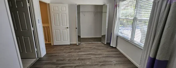 a view of a hallway with wooden floor and staircase