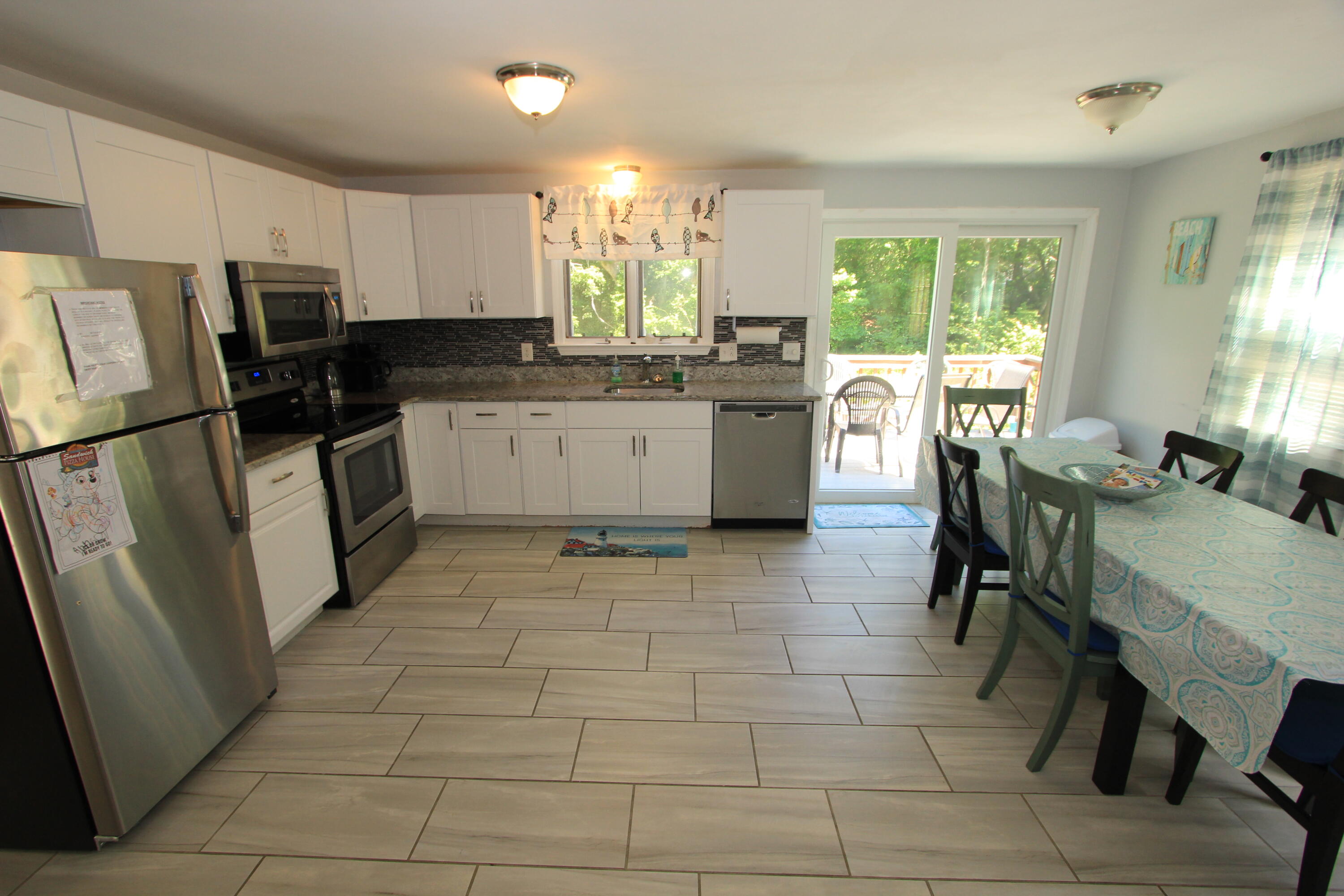 23 Nauset Road Sagamore Beach, MA 02562 - Photo 3 of 13 a kitchen with a sink a counter top space appliances and cabinets