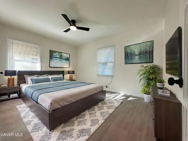 a bedroom with a bed a couch and a potted plant