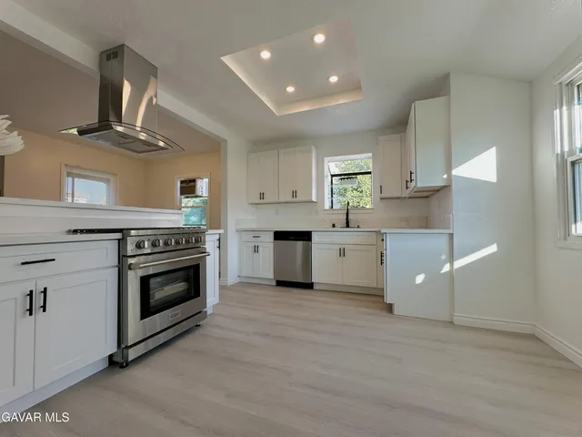 a kitchen with a stove oven and white cabinets