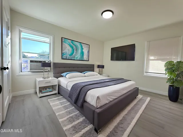 a spacious bedroom with a bed and a potted plant