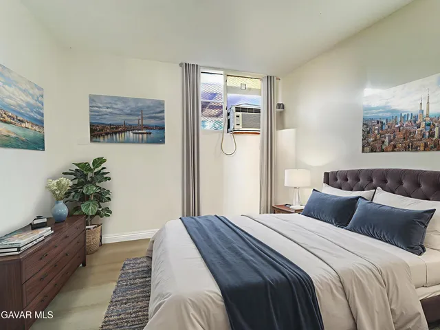 a bedroom with bed and wooden floor