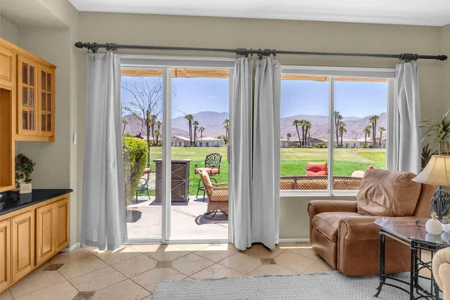 a living room with furniture and a floor to ceiling window