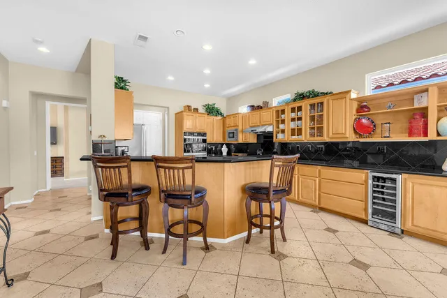 a kitchen with stainless steel appliances kitchen island granite countertop a table and chairs in it