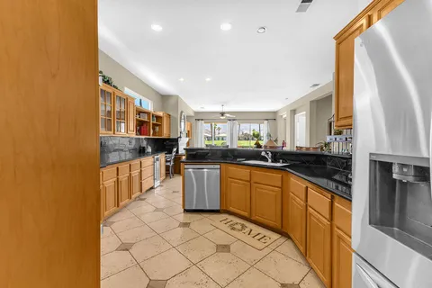 a kitchen with stainless steel appliances granite countertop a stove a sink and a refrigerator