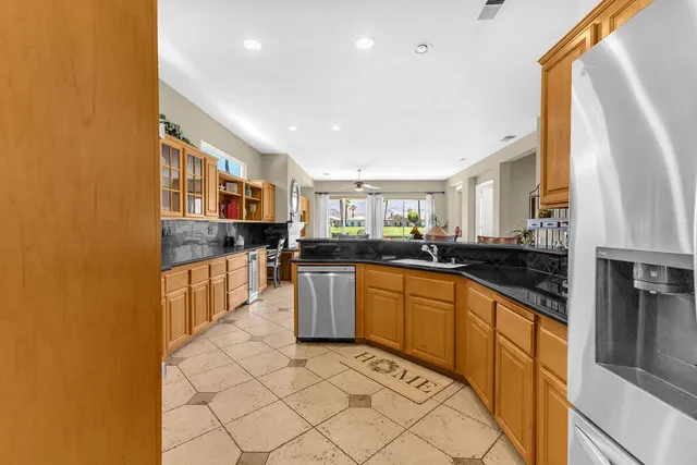 a kitchen with stainless steel appliances granite countertop a stove a sink and a refrigerator