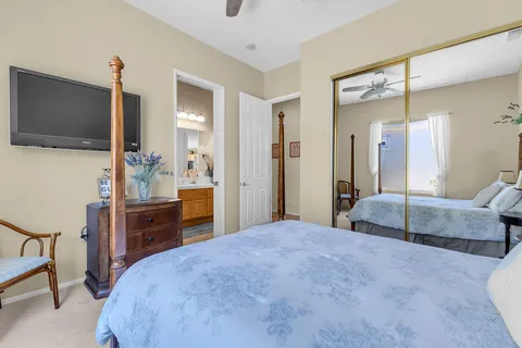 a spacious bedroom with a bed and a flat screen tv