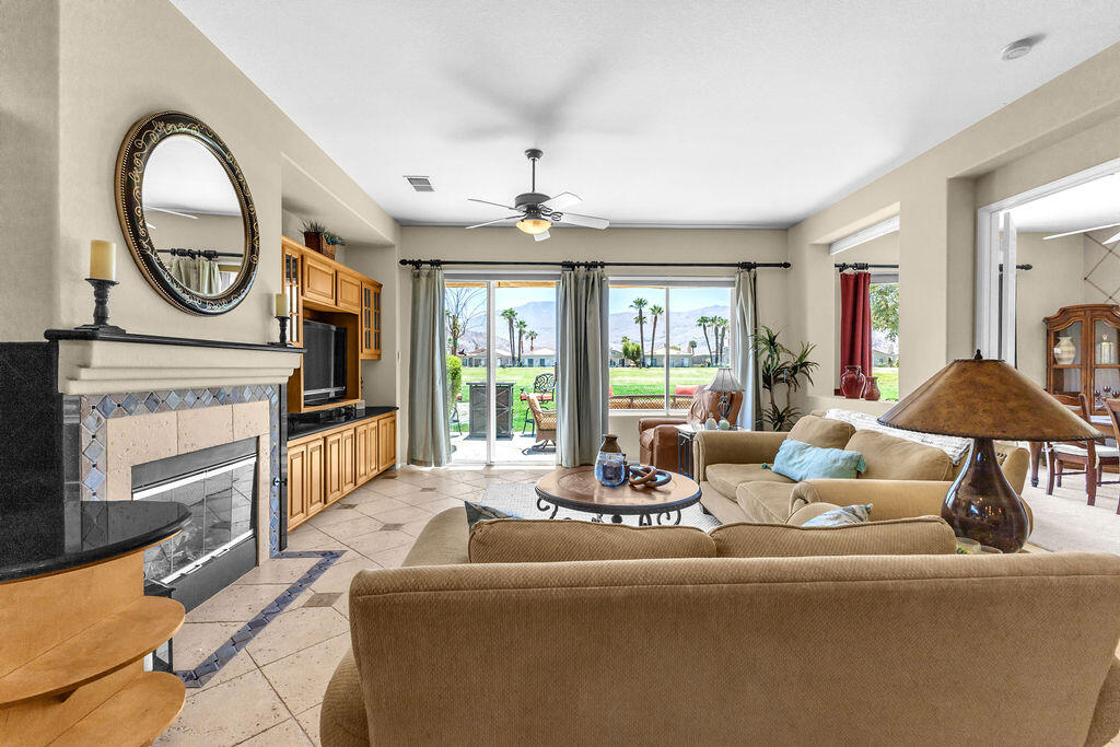 78079 Calle Norte La Quinta, CA 92253 - Photo 7 of 51 a living room with furniture a fireplace a chandelier and windows
