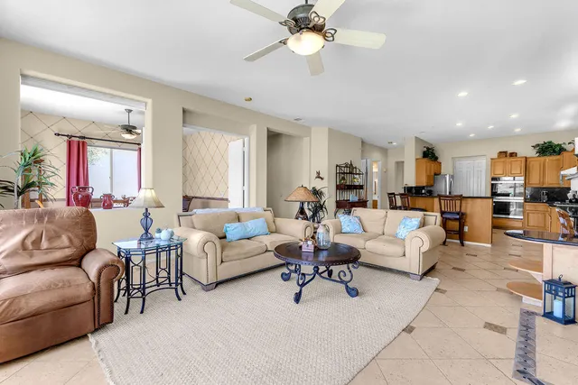 a living room with furniture kitchen view and a chandelier