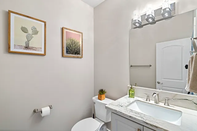 a bathroom with a granite countertop sink mirror and toilet