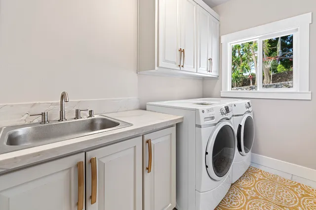 a utility room with sink dryer and washer