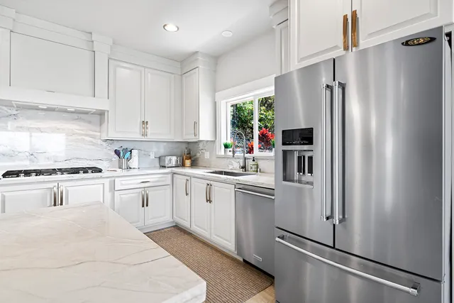a kitchen with stainless steel appliances granite countertop a refrigerator sink and stove