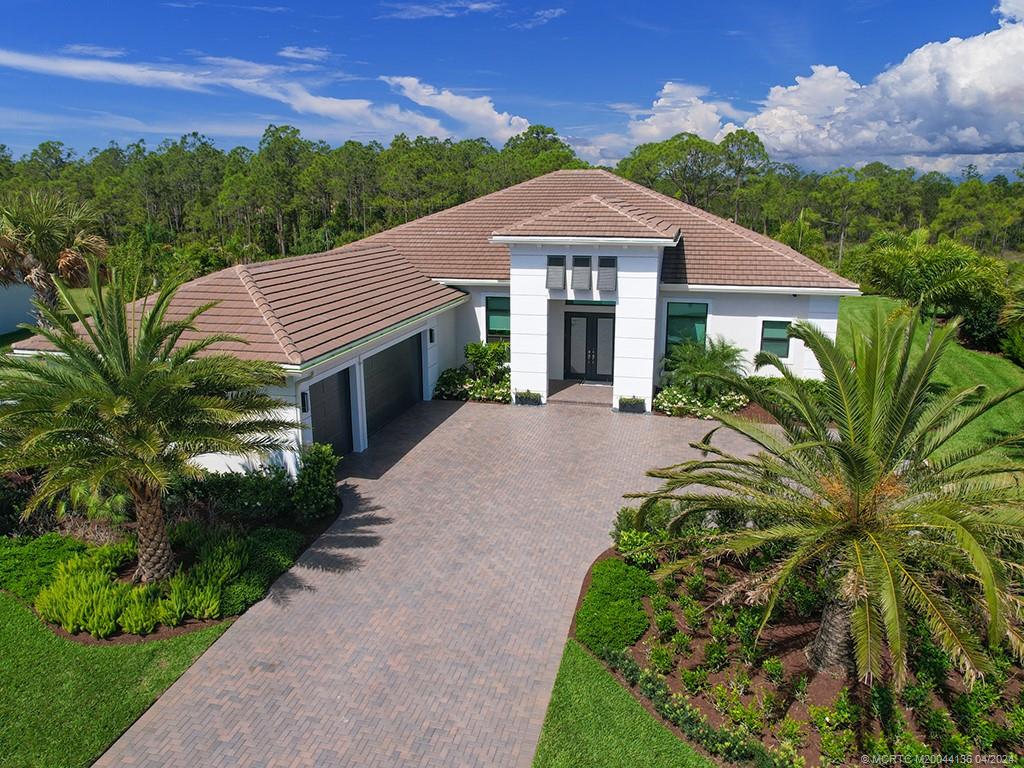3246 Southwest Loriope Loop Palm City, FL 34990 - Photo 1 of 37 a front view of a house with a yard