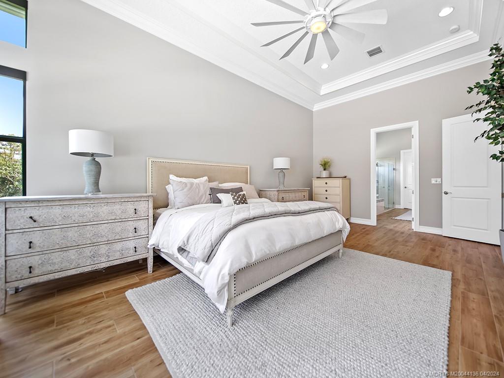 3246 Southwest Loriope Loop Palm City, FL 34990 - Photo 15 of 37 a bedroom with a bed and a chandelier