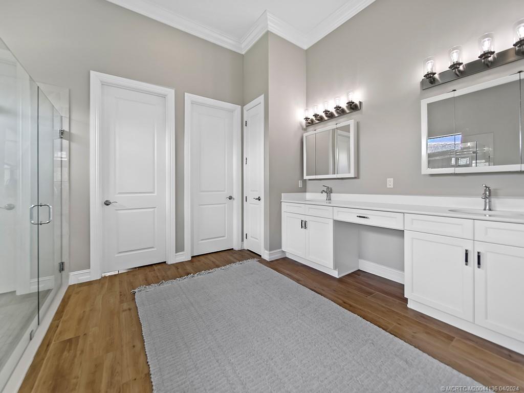 3246 Southwest Loriope Loop Palm City, FL 34990 - Photo 18 of 37 a spacious bathroom with a double vanity sink a mirror and shower