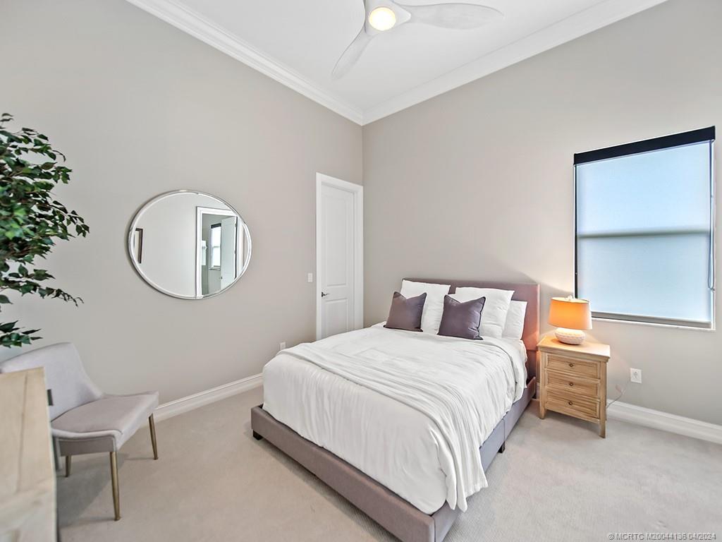 3246 Southwest Loriope Loop Palm City, FL 34990 - Photo 20 of 37 a bedroom with a bed a mirror and a potted plant