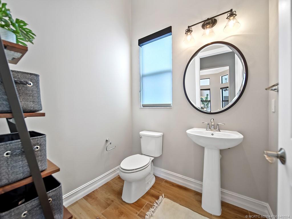 3246 Southwest Loriope Loop Palm City, FL 34990 - Photo 24 of 37 a bathroom with a toilet sink and mirror