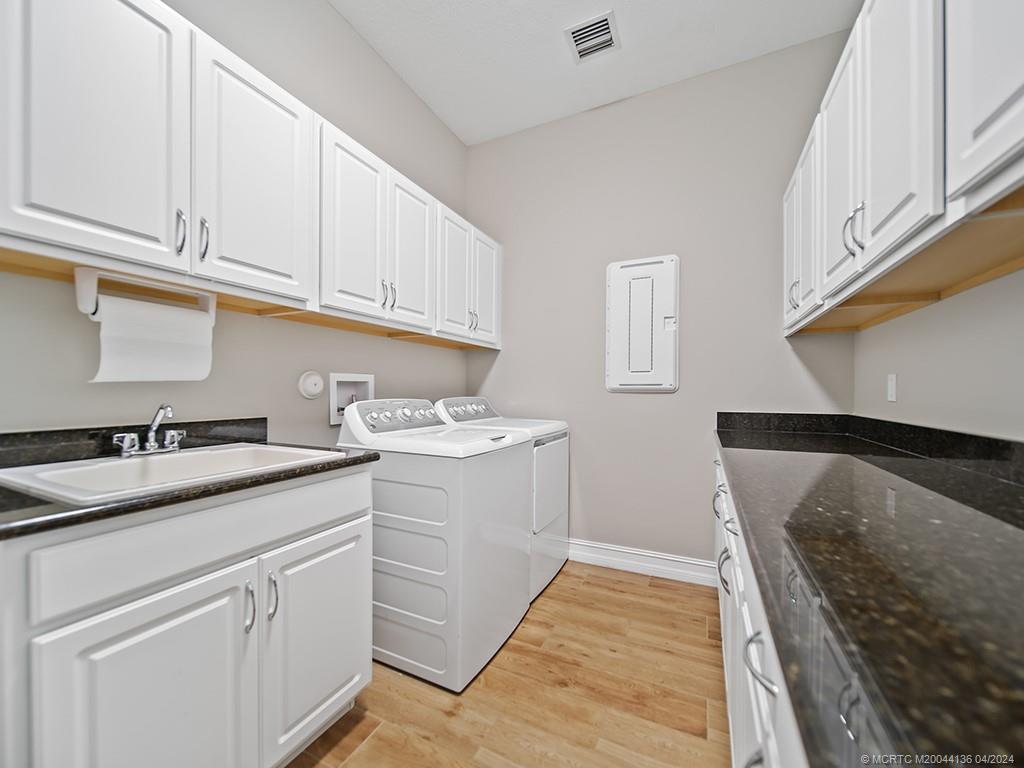 3246 Southwest Loriope Loop Palm City, FL 34990 - Photo 25 of 37 a kitchen with a sink stove and cabinets