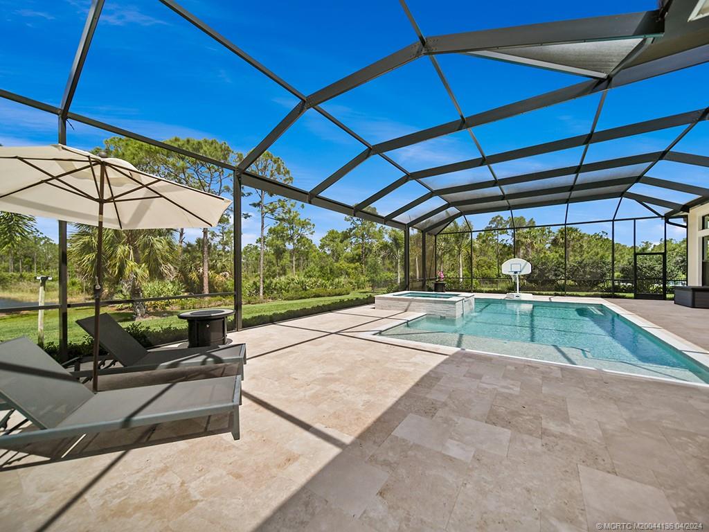 3246 Southwest Loriope Loop Palm City, FL 34990 - Photo 29 of 37 a view of a backyard with table and chairs under an umbrella