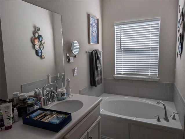 a bathroom with a tub sink and a mirror