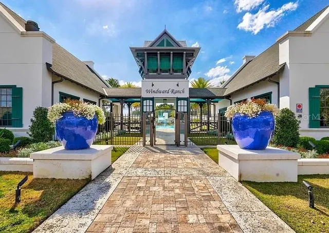 a front view of a house with a large window and potted plants