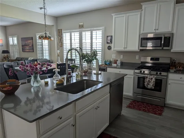 a kitchen with kitchen island granite countertop stainless steel appliances a sink stove and cabinets