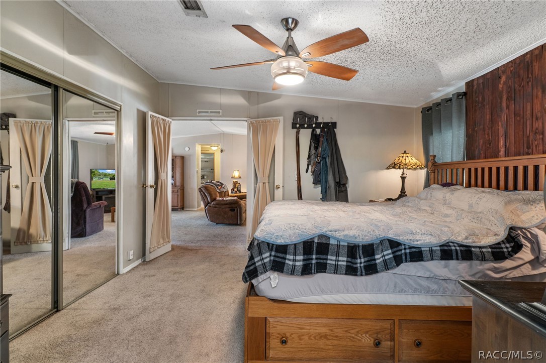 7927 West Cyprian Court Homosassa, FL 34448 - Photo 22 of 40 a spacious bedroom with a bed and a chandelier