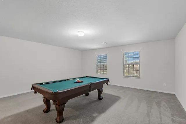 a room with pool table and windows