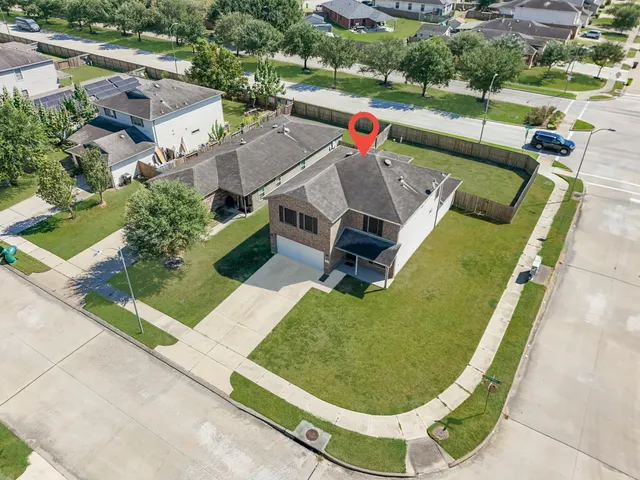 an aerial view of a house with swimming pool and outdoor seating