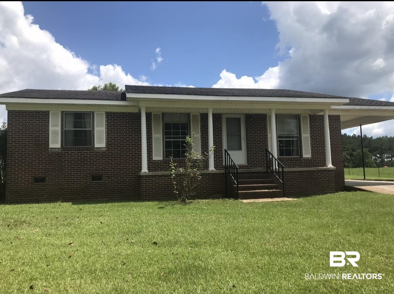 6325 Butler Street Frisco City, AL 36445 - Photo 1 of 15 View of front of property with crawl space, brick siding, a front yard, and a porch
