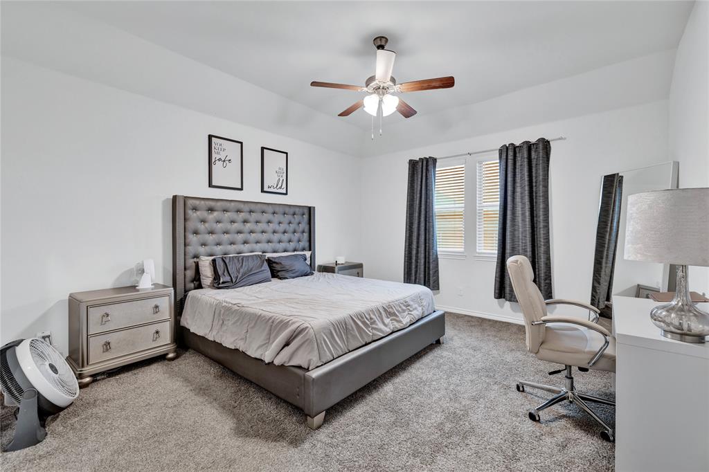 717 Rawhide Way Princeton, TX 75407 - Photo 9 of 31 a bedroom with a bed a chandelier and dresser