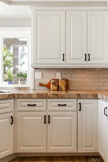 a kitchen with granite countertop white cabinets and white appliances