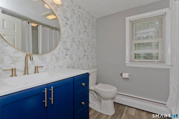 a bathroom with a sink a toilet and shower