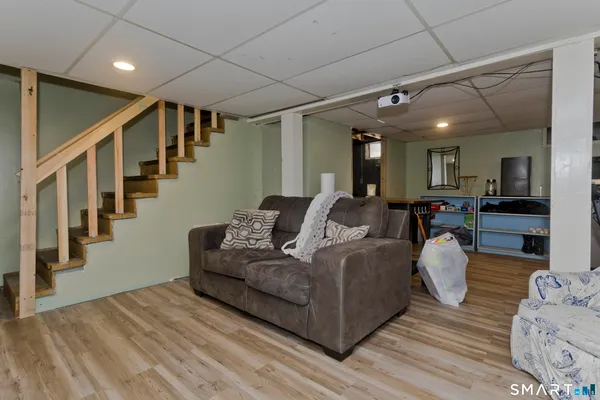 a view of an empty room with wooden floor and staircase
