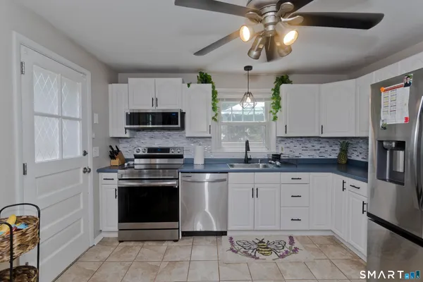 a kitchen with stainless steel appliances granite countertop a stove sink and cabinets